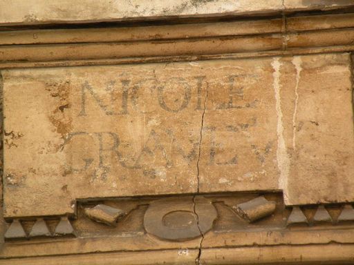  inscription à demi effacée au-dessus d'une porte d'immeuble, grande rue